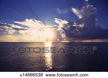 Stock Photograph - the deep blue 
ocean reflecting 
the lights of 
the setting sun 
under a. fotosearch 
- search stock 
photos, pictures, 
images, and photo 
clipart