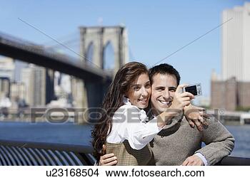 Stock Photo - couple taking 
photograph of 
themselves,  brooklyn 
bridge in. fotosearch 
- search stock 
photos, pictures, 
images, and photo 
clipart