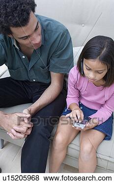 Stock Photo - portrait of father 
watching his daughter 
use a palm pilot. 
fotosearch - search 
stock photos, 
pictures, images, 
and photo clipart