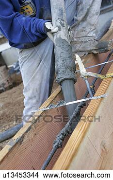 Stock Photo - construction worker 
pouring concrete 
into form wall 
with rebar for. 
fotosearch - search 
stock photos, 
pictures, images, 
and photo clipart