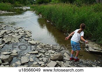 Arquivo Fotográficos - jovem,  menina, 
 saltando,  pedras, 
 rio. fotosearch 
- busca de fotos, 
imagens e clipart
