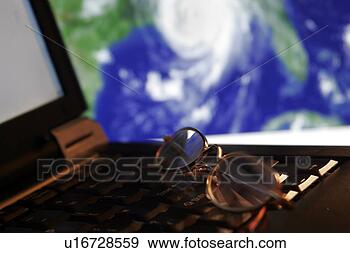 Stock Photograph - tracking a hurricane 
portrayed by eyeglasses 
atop a laptop 
computer. fotosearch 
- search stock 
photos, pictures, 
images, and photo 
clipart