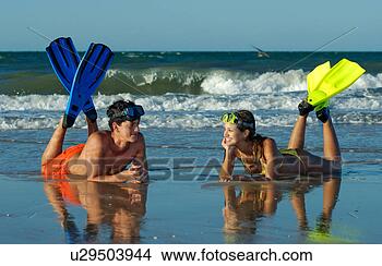 Stock Photo - young couple relaxing 
on the beach after 
a snorkel diving. 
fotosearch - search 
stock photos, 
pictures, images, 
and photo clipart