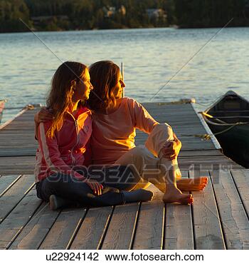Stock Photo - mother and daughter 
sitting on dock 
at sunset. fotosearch 
- search stock 
photos, pictures, 
images, and photo 
clipart
