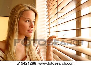 Stock Photo - woman looking 
out through venetian 
blinds. fotosearch 
- search stock 
photos, pictures, 
images, and photo 
clipart