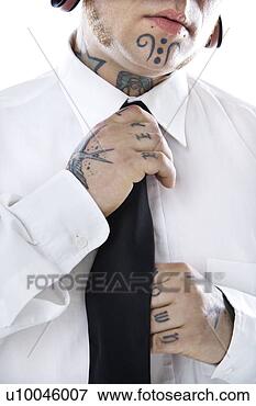 Picture - caucasian mid-adult 
man with tattoos 
and piercings 
adjusting necktie. 
fotosearch - search 
stock photos, 
pictures, images, 
and photo clipart