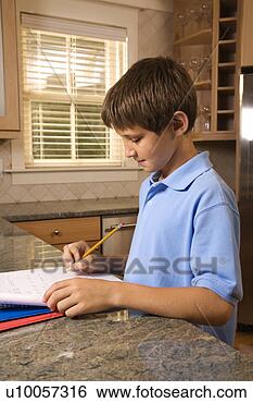 Stock Photo - caucasian pre-teen 
boy doing homework 
at kitchen counter. 
fotosearch - search 
stock photos, 
pictures, images, 
and photo clipart