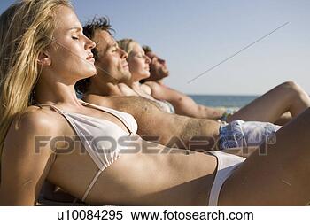 Stock Image - two couples lying 
on beach. fotosearch 
- search stock 
photos, pictures, 
images, and photo 
clipart