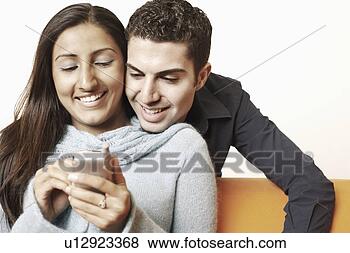 Stock Photo - close-up of a 
young couple using 
a mobile phone. 
fotosearch - search 
stock photos, 
pictures, images, 
and photo clipart