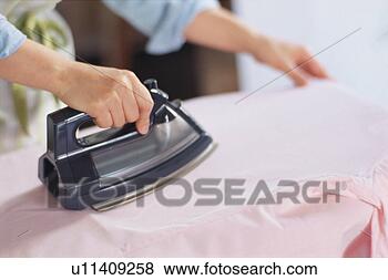 Stock Photo - mid adult woman 
ironing, close-up. 
fotosearch - search 
stock photos, 
pictures, images, 
and photo clipart