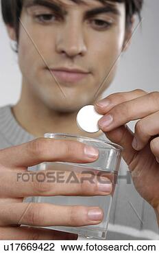 Stock Photo - man dropping fizzy 
tablet in glass 
of water. fotosearch 
- search stock 
photos, pictures, 
images, and photo 
clipart