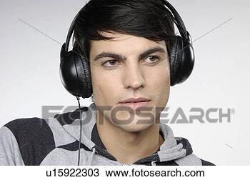 Stock Photo - young man listening 
to music with 
headphones. fotosearch 
- search stock 
photos, pictures, 
images, and photo 
clipart