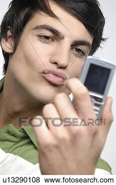 Stock Photo - young man taking 
a picture of himself 
with his camera 
phone, pouting. 
fotosearch - search 
stock photos, 
pictures, images, 
and photo clipart