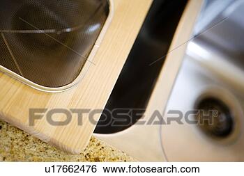 Stock Photo - cutting board 
and strainer sitting 
on kitchen sink. 
fotosearch - search 
stock photos, 
pictures, images, 
and photo clipart