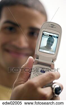 Stock Image - african man using 
camera phone to 
take self-portrait. 
fotosearch - search 
stock photos, 
pictures, images, 
and photo clipart