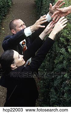 Stock Photo - businessman and 
businesswoman 
reaching help 
over a hedge. 
fotosearch - search 
stock photos, 
pictures, images, 
and photo clipart