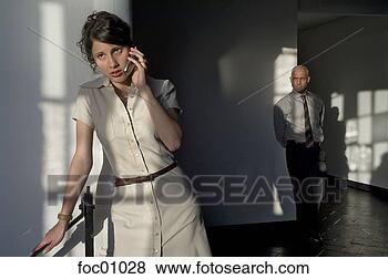 Stock Photo - businessman eavesdropping 
on businesswoman's 
cell phone conversation. 
fotosearch - search 
stock photos, 
pictures, images, 
and photo clipart