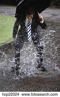 Stock Photo - businessman splashing 
in rain puddle. 
fotosearch - search 
stock photos, 
pictures, images, 
and photo clipart