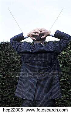 Stock Image - frustrated businessman 
looking at hedge. 
fotosearch - search 
stock photos, 
pictures, images, 
and photo clipart