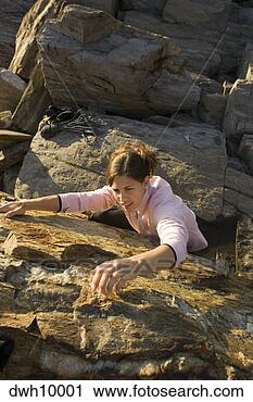 Stock Photography - high angle view 
of woman rock 
climbing. fotosearch 
- search stock 
photos, pictures, 
images, and photo 
clipart