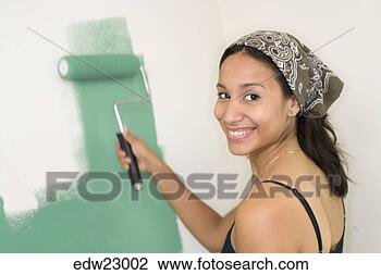 Stock Photo - hispanic woman 
painting with 
roller. fotosearch 
- search stock 
photos, pictures, 
images, and photo 
clipart