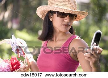 Picture - indian woman gardening 
and using cell 
phone. fotosearch 
- search stock 
photos, pictures, 
images, and photo 
clipart