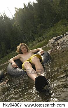 Picture - man floating on 
water in inflatable 
ring. fotosearch 
- search stock 
photos, pictures, 
images, and photo 
clipart