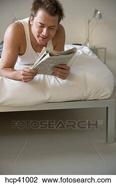 Stock Photo - man reading newspaper 
on bed. fotosearch 
- search stock 
photos, pictures, 
images, and photo 
clipart
