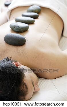 Stock Photography - man with therapeutic 
hot stones on 
back. fotosearch 
- search stock 
photos, pictures, 
images, and photo 
clipart