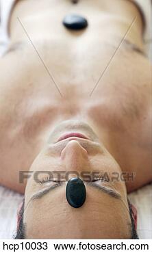 Stock Photo - man with therapeutic 
hot stones on 
forehead and torso. 
fotosearch - search 
stock photos, 
pictures, images, 
and photo clipart