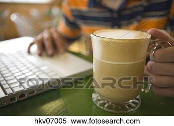 Stock Image - man using laptop 
in cafe and drinking 
coffee. fotosearch 
- search stock 
photos, pictures, 
images, and photo 
clipart
