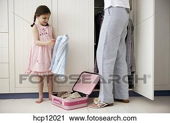 Stock Photography - mother and daughter 
packing suitcase. 
fotosearch - search 
stock photos, 
pictures, images, 
and photo clipart