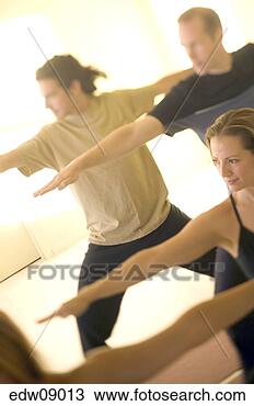 Stock Photo - people practicing 
yoga, warrior 
pose. fotosearch 
- search stock 
photos, pictures, 
images, and photo 
clipart