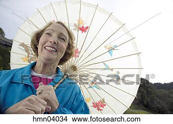 Stock Photo - senior woman using 
parasol. fotosearch 
- search stock 
photos, pictures, 
images, and photo 
clipart