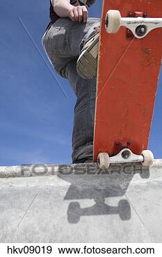 Stock Photograph - skateboarder standing 
on edge of ramp. 
fotosearch - search 
stock photos, 
pictures, images, 
and photo clipart