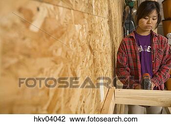Stock Photo - teenage girl using 
drill. fotosearch 
- search stock 
photos, pictures, 
images, and photo 
clipart