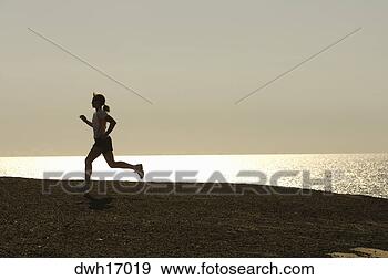 Stock Photograph - woman jogging 
along shore. fotosearch 
- search stock 
photos, pictures, 
images, and photo 
clipart