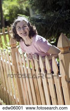 Stock Photography - woman leaning 
over fence. fotosearch 
- search stock 
photos, pictures, 
images, and photo 
clipart