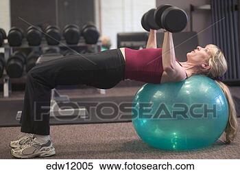Stock Image - woman lifting 
weights on exercise 
ball. fotosearch 
- search stock 
photos, pictures, 
images, and photo 
clipart
