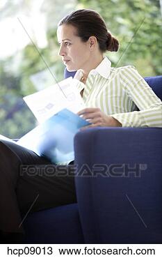 Stock Photo - woman looking 
through papers 
in armchair. fotosearch 
- search stock 
photos, pictures, 
images, and photo 
clipart