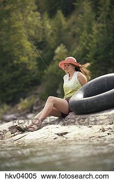 Stock Image - woman sitting 
on beach with 
inflatable ring. 
fotosearch - search 
stock photos, 
pictures, images, 
and photo clipart