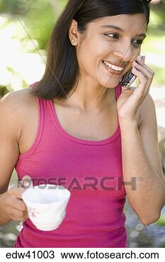 Stock Photo - woman talking 
on cell phone 
while having tea. 
fotosearch - search 
stock photos, 
pictures, images, 
and photo clipart