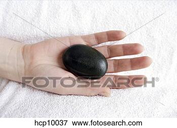 Picture - woman with therapeutic 
hot stone on palm. 
fotosearch - search 
stock photos, 
pictures, images, 
and photo clipart