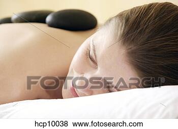 Stock Photo - woman with therapeutic 
hot stones on 
back. fotosearch 
- search stock 
photos, pictures, 
images, and photo 
clipart
