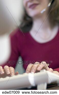 Stock Photograph - woman using headset 
while working. 
fotosearch - search 
stock photos, 
pictures, images, 
and photo clipart