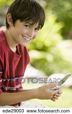Stock Photo - young boy using 
cell phone. fotosearch 
- search stock 
photos, pictures, 
images, and photo 
clipart