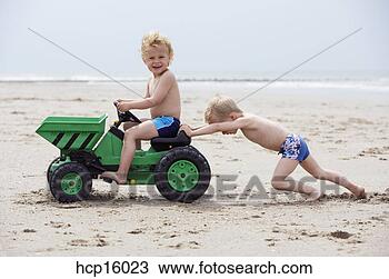 Stock Photo - young boys playing 
with toy digger 
on beach. fotosearch 
- search stock 
photos, pictures, 
images, and photo 
clipart
