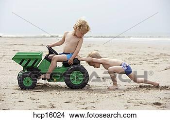 Stock Photo - young boys playing 
with toy digger 
on beach. fotosearch 
- search stock 
photos, pictures, 
images, and photo 
clipart