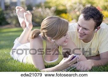 Stock Photograph - young couple listening 
to music on same 
headset. fotosearch 
- search stock 
photos, pictures, 
images, and photo 
clipart