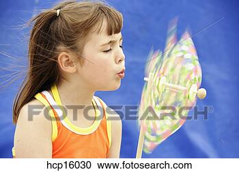 Stock Photography - young girl blowing 
pinwheel. fotosearch 
- search stock 
photos, pictures, 
images, and photo 
clipart